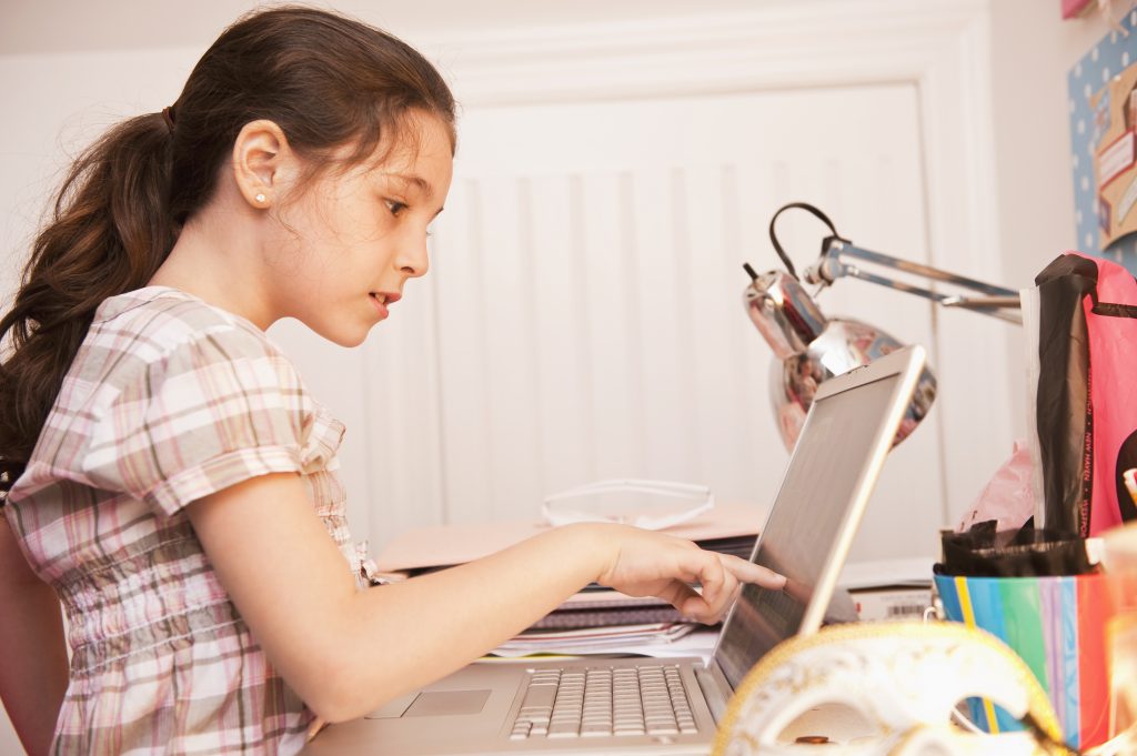 Dziewczynka wskazująca palcem na ekran laptopa